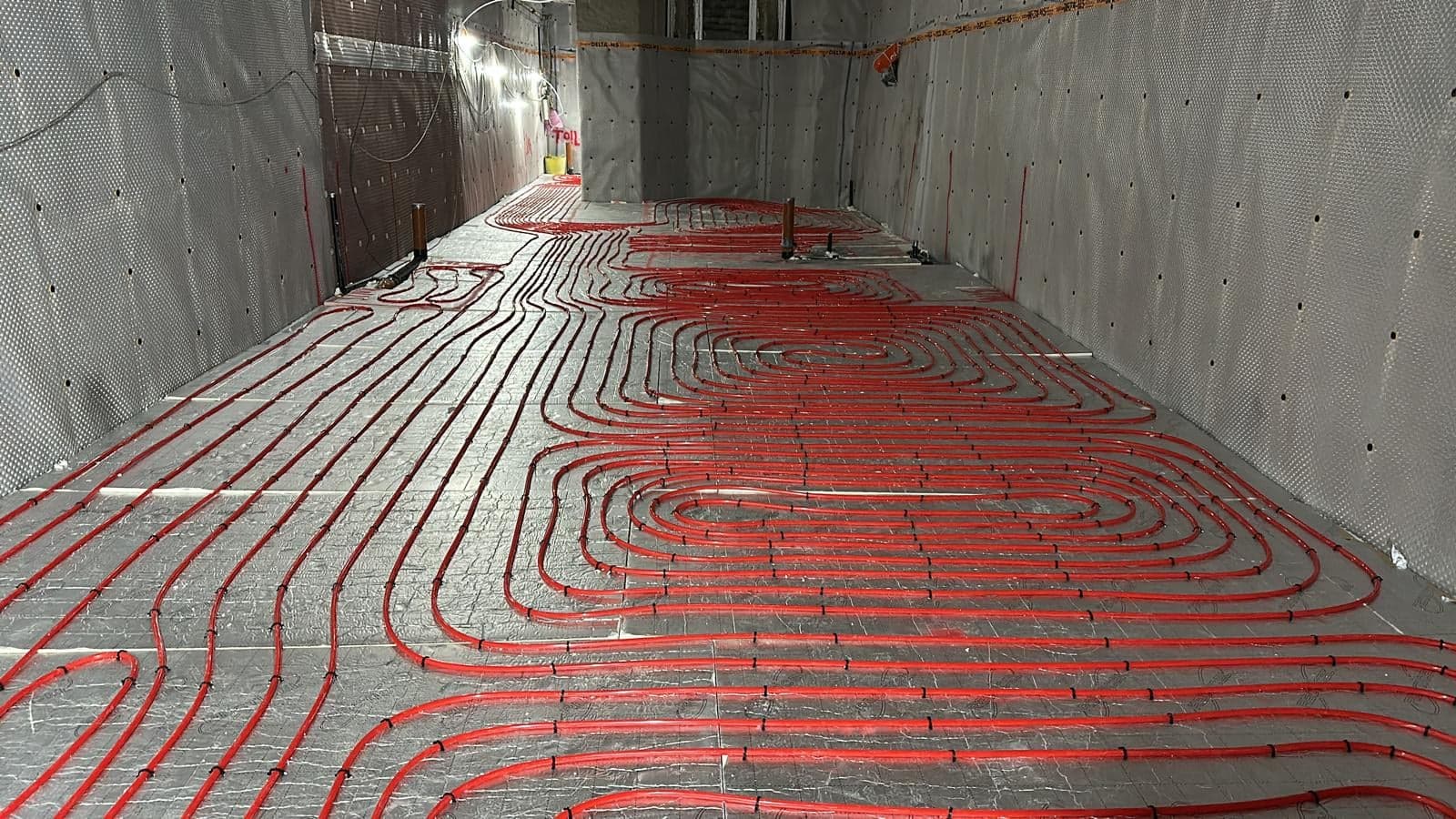 Basement floor covered in underfloor heating pipes, ready for the screed