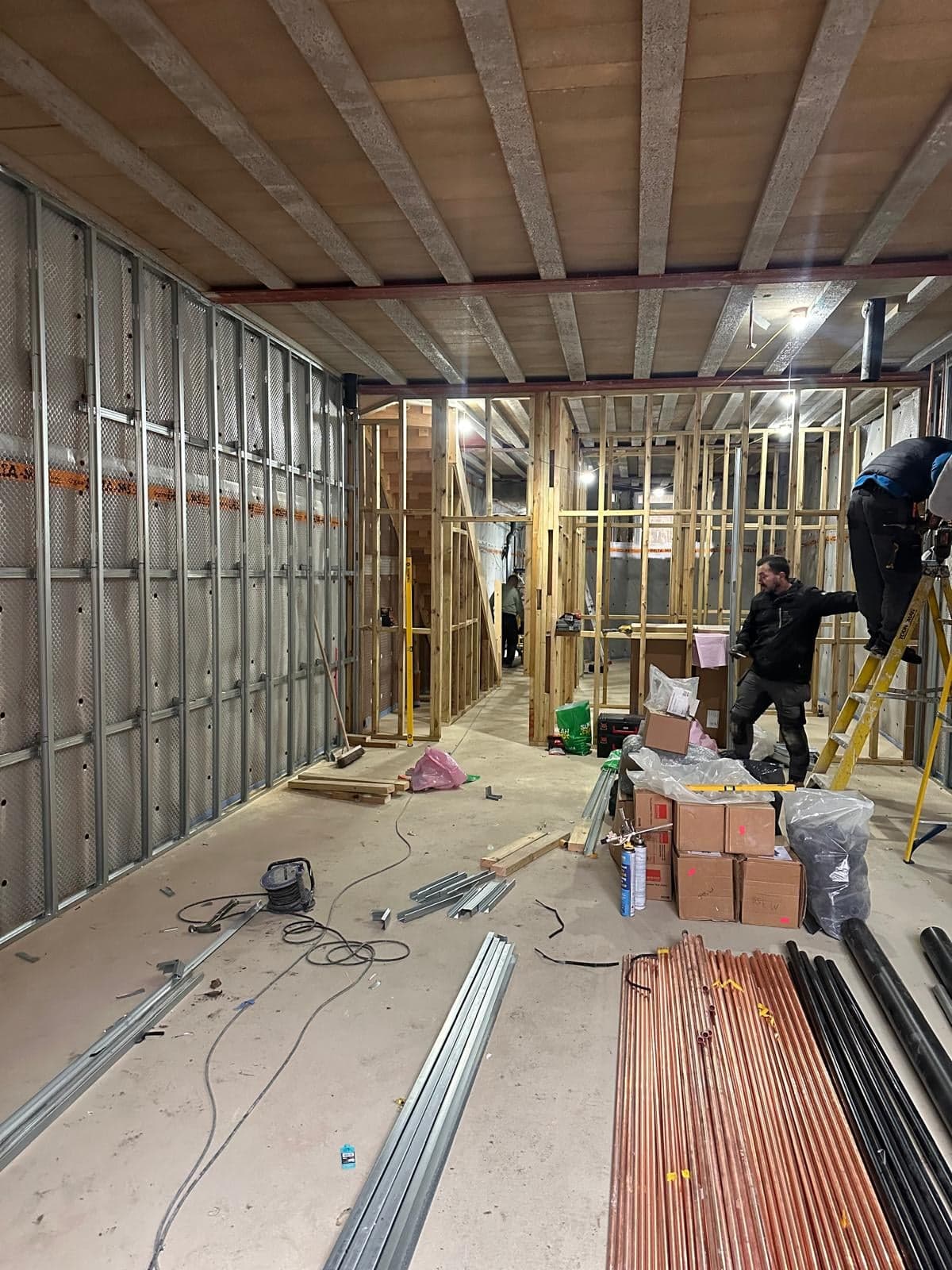 Metal stud walls and services going in across the new basement