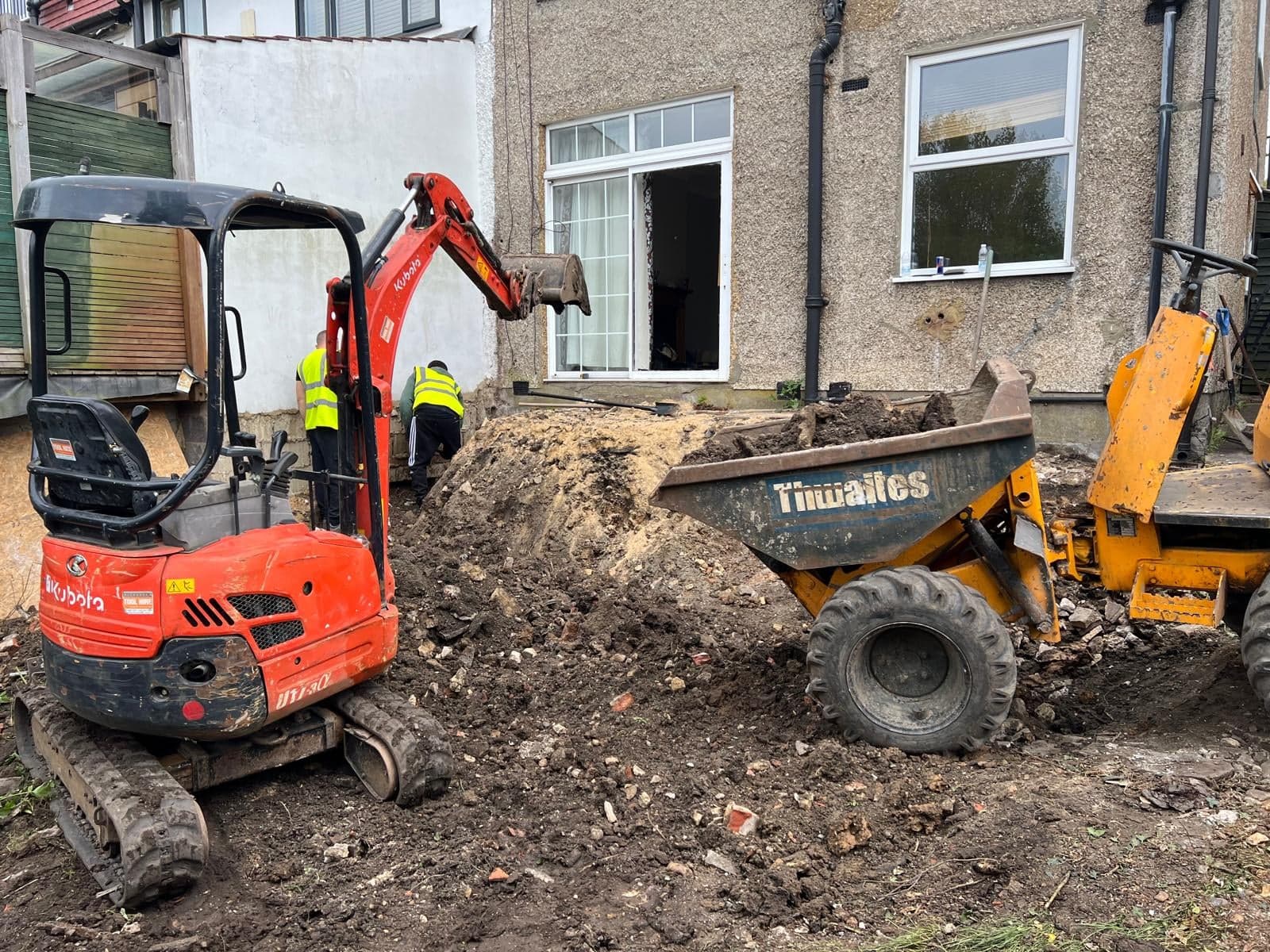 Mini excavator and dumper clearing and digging out a back garden