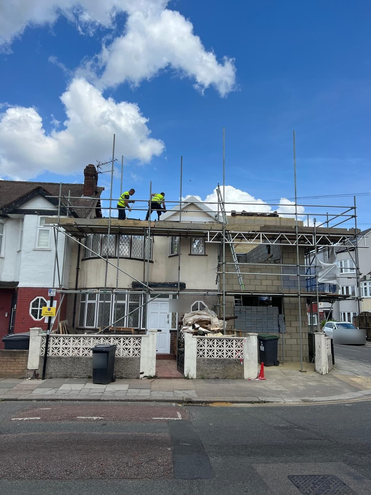 Two of the team working on the roof for the loft extension, with the house under scaffold