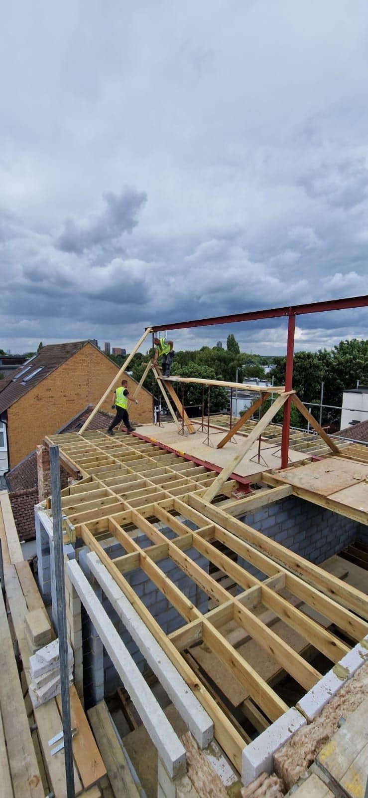 Loft joists and a steel frame going in, with the old roof opened up
