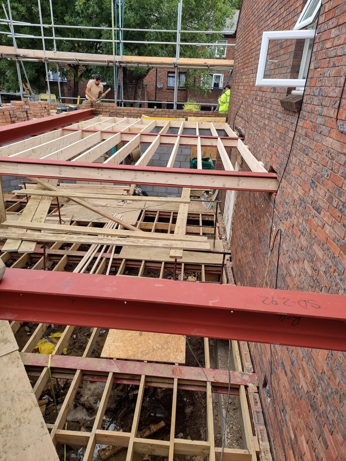 First-floor joists and steel across the new house, seen from the scaffold