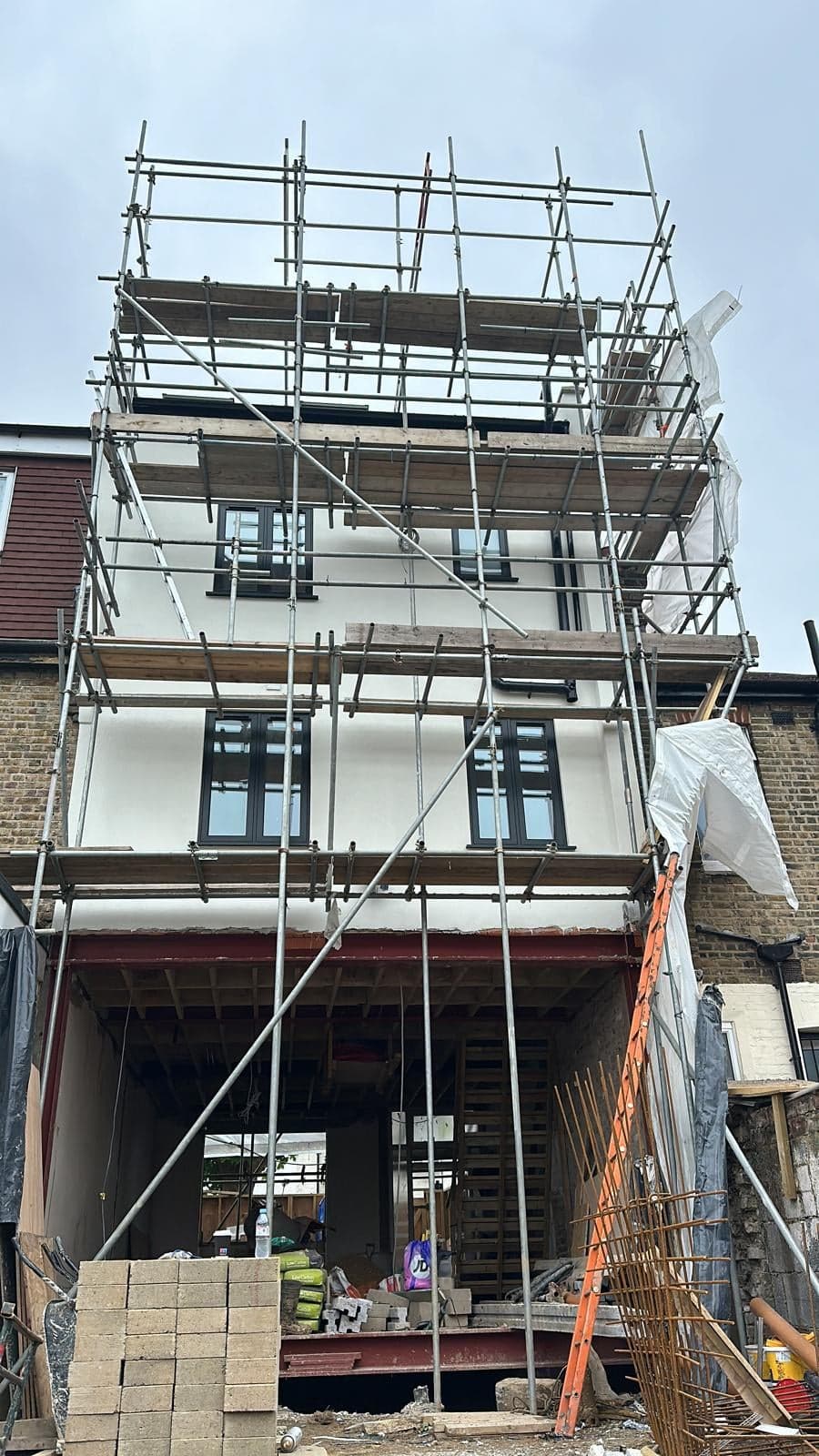 Front of the house under scaffold, with the ground floor opened up on new steel