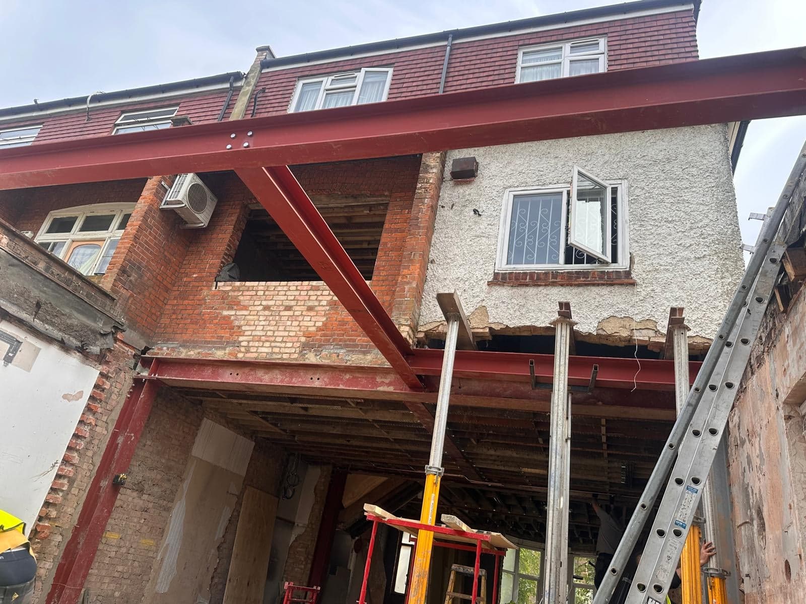 Steel frame and props carrying the upper floors while the back of a house is opened up