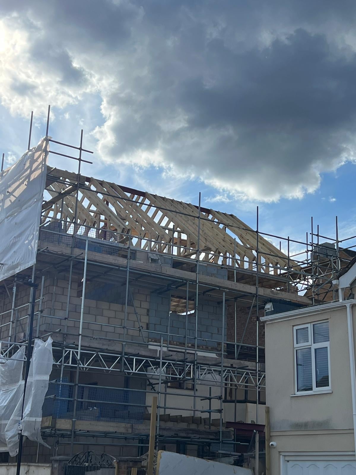 New roof trusses on a two-storey extension, under scaffold